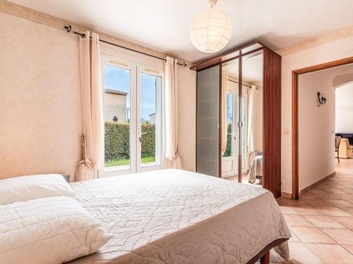 une chambre avec un grand lit et une grande fenêtre dans l'établissement Holiday Home Villa la pivoine by Interhome, à Six-Fours-les-Plages