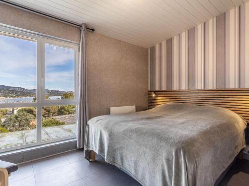 une chambre avec un lit et une grande fenêtre dans l'établissement Apartment Les Villas de la Baie by Interhome, à Cavalaire-sur-Mer