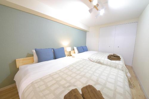 a bedroom with two beds with blue pillows at ノーザンヒルズ南6条 in Sapporo