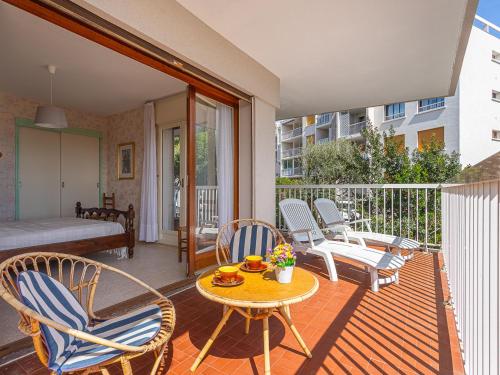 un patio avec une table et des chaises sur un balcon dans l'établissement Apartment Les Mimosas-8 by Interhome, à Cavalaire-sur-Mer