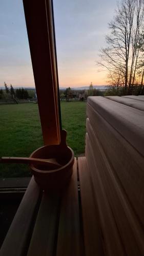 a bowl sitting on a window sill looking out at a field at Szychów z widokiem in Stara Łomnica