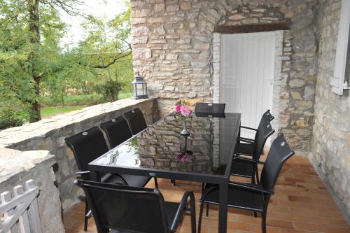 une table noire et des chaises sur une terrasse dans l'établissement Le Mas de la Colombe, à Grospierres