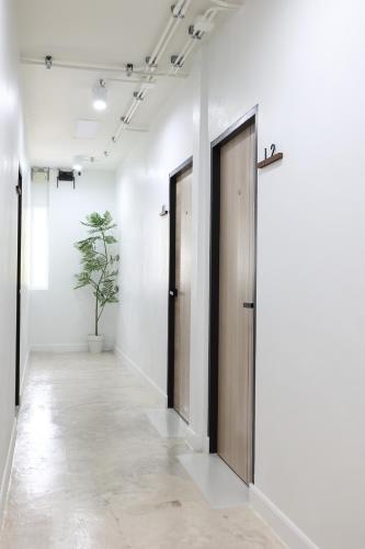 a hallway with two doors and a potted plant at Lfour phuket in Phuket Town