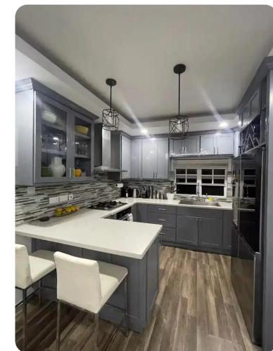 a kitchen with gray cabinets and a white counter top at Cypress Suites in Goodwill