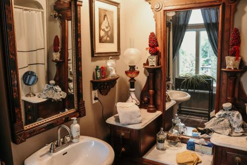 a bathroom with a sink and a mirror at Gîte au Charme Victorien in Beauceville