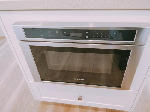 Un horno microondas dentro de un armario blanco. en FB Master, en Irvine