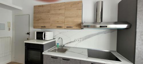 a kitchen with a sink and a microwave at Torremolinos CARIHUELA RENOVADO - Wifi 365 Mbps - Fire Stick Amazon - Playa a 50 metros in Torremolinos