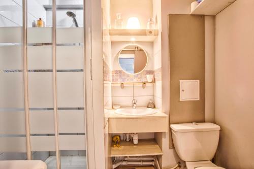 une petite salle de bain avec un lavabo et des toilettes dans l'établissement Le Montebello - Gare accessible à pied - Centre Ville, à Trouville-sur-Mer