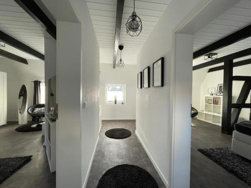 a living room with white walls and a hallway with rugs at Fachwerkhaus mit 2 getrennten Schlafzimmern, Wohnzimmer und Küche in Bückeburg