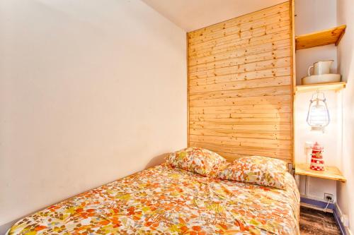 une chambre avec un lit avec une tête de lit en bois dans l'établissement Le Montebello - Gare accessible à pied - Centre Ville, à Trouville-sur-Mer