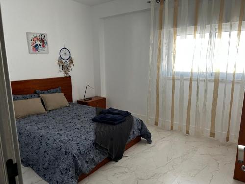 a bedroom with a bed and a window at One-bedroom in Alvor with a Sea View Fully Renovated in Bicas