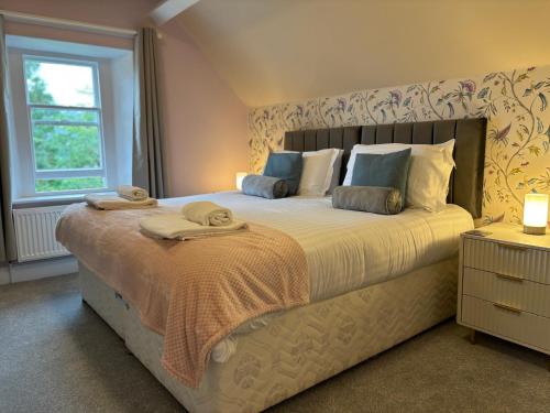 una camera da letto con un letto grande con asciugamani sopra di Fell215 - Classic loft apartment at The Lairbeck in Keswick a Keswick