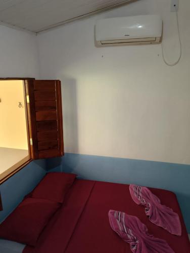 a small room with a bed and a fan at Chales do porto in Ilha de Boipeba
