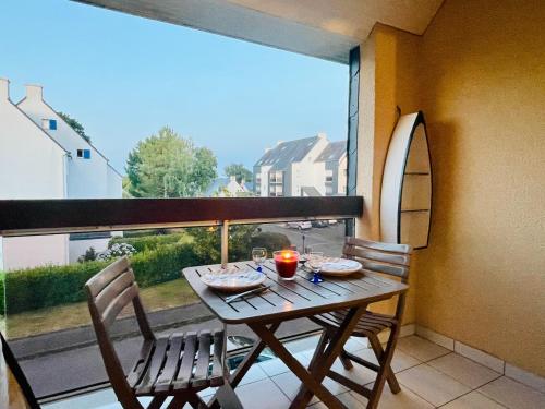 ein Tisch und Stühle auf einem Balkon mit Fenster in der Unterkunft Une pause à Bénodet in Bénodet