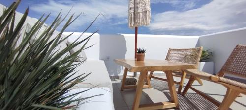 a table and chairs on a balcony with a plant at Kamvas Deluxe Apartments in Naxos Chora