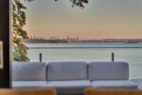 a white couch sitting next to a body of water at The Sunset Lane Waterfront Home in West Vancouver