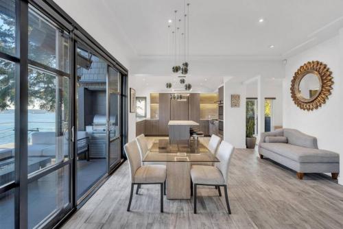 a living room with a table and chairs at The Sunset Lane Waterfront Home in West Vancouver