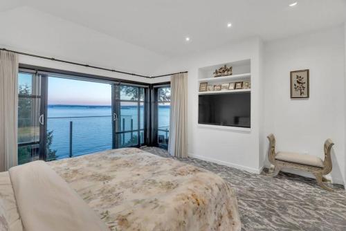 a bedroom with a bed and a view of the water at The Sunset Lane Waterfront Home in West Vancouver