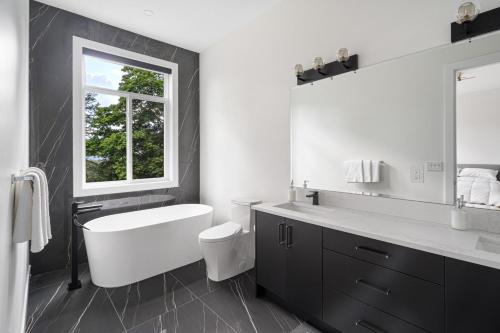 a bathroom with a tub and a toilet and a sink at Stylish Retreat in Agassiz with Scenic Views in Agassiz
