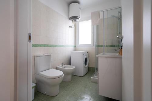 a white bathroom with a toilet and a sink at Sea Residence LUNA ROSSA in Marzamemi