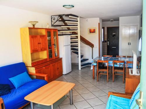 un salon avec un canapé bleu et une table dans l'établissement Apartment Coudalère-Guadeloupe-10 by Interhome, au Barcarès