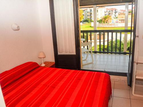 - une chambre avec un lit rouge et un balcon dans l'établissement Apartment Coudalère-Guadeloupe-10 by Interhome, au Barcarès