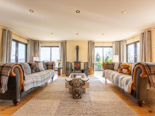 a living room with two couches and a fireplace at Villa Drover's Lodge by Interhome in Drumnadrochit