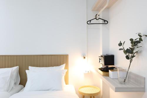 a bedroom with a white bed and a tv at Lfour phuket in Phuket Town