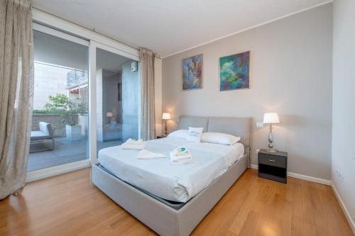 a bedroom with a bed and a large window at MGH Luxury - Residenza La Perla Peschiera Lakefront in Peschiera del Garda