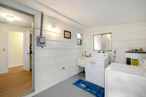 a white kitchen with a sink and a washing machine at Gulf Girl a vintage Cedar Key retreat in Cedar Key