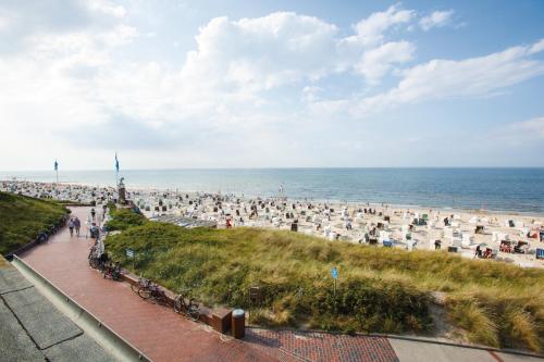 a crowd of people on a beach with the ocean at Strandhotel Gerken in Wangerooge