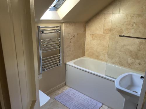 a bathroom with a bath tub and a toilet at The Hayloft in Lastingham