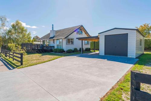 a driveway with a garage in front of a house at Little Lake House - Kinloch in Kinloch
