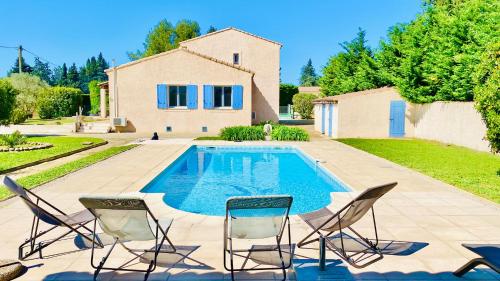 une piscine avec des chaises et une maison dans l'établissement 