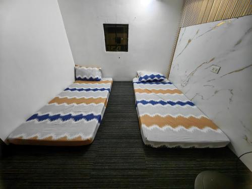 two beds are sitting in a room at Luna Modern Guesthouse Loft House up and Down in Lipa