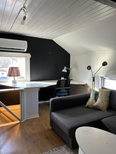 a living room with a couch and a desk at Brahegatan in Sala