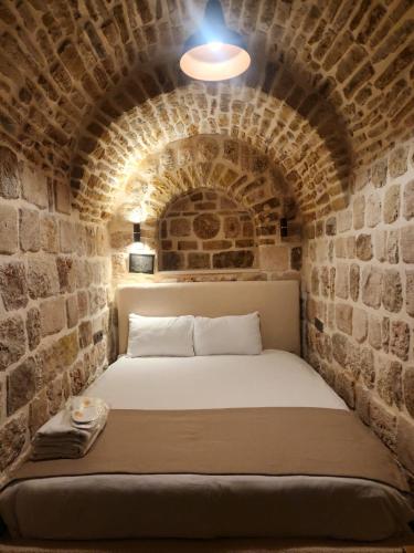 a bed in a room with a brick wall at Ana Talia House in Mardin