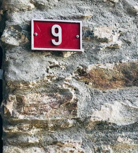 a red sign on the side of a stone wall at Rustico Il Nove in Piazzogna