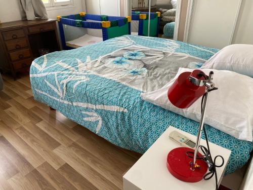 - une chambre avec un lit et une lampe rouge sur une table dans l'établissement Maison 3 chambres gde terrasse proche vieux port et sncf, à Marseille