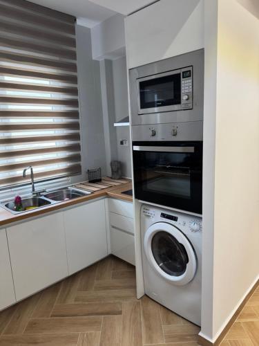 a kitchen with a washing machine and a microwave at Sea & Luxury in Perea