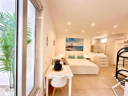 a bedroom with a bed and a desk and a table at Torre Pozzillo Beach in Cinisi