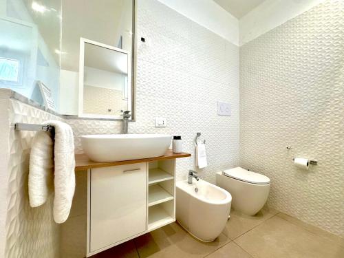 a white bathroom with a sink and a toilet at Torre Pozzillo Beach in Cinisi