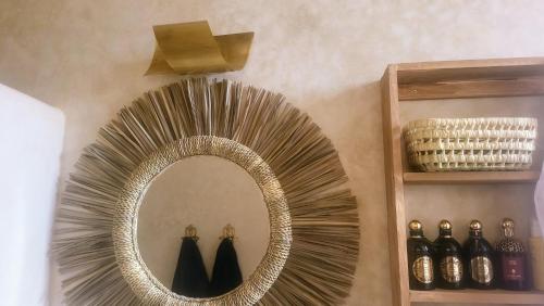 a gold mirror on a wall next to a shelf at VILLA ORSON - ESSAOUIRA Ghazoua in Ghazoua