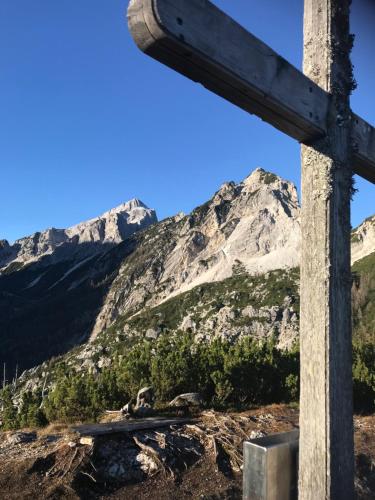a wooden cross in front of a mountain at Planinski dom - Mihov dom na Vršiču in Kranjska Gora