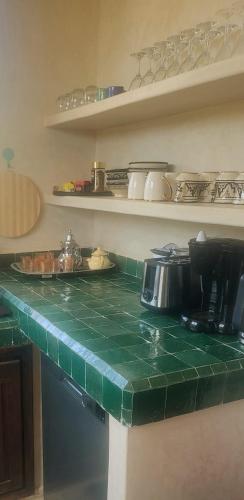 a green counter top in a kitchen with shelves at VILLA ORSON - ESSAOUIRA Ghazoua in Ghazoua