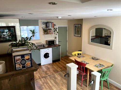 eine Küche mit einem Tisch und einer Waschmaschine in der Unterkunft Railway Cottage Horsforth in Horsforth