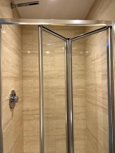 a shower with a glass door in a bathroom at Railway Cottage Horsforth in Horsforth