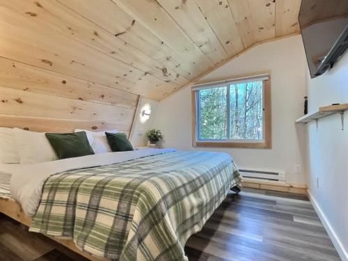 a bedroom in a tiny house with a bed at HappyCub- AC, Hot Tub, Fire Pit, Game Room! in Killington