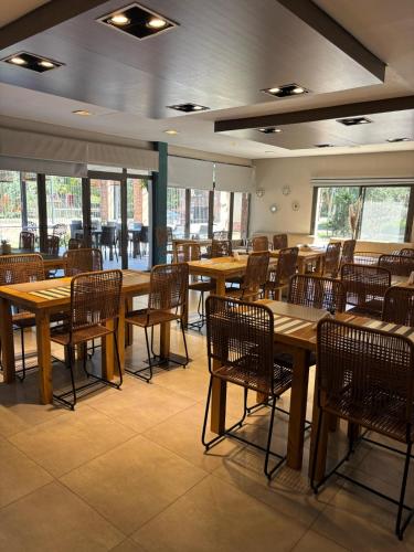 ピラルにあるPilar Suites by Vivaの木製のテーブルと椅子が置かれた空のレストラン