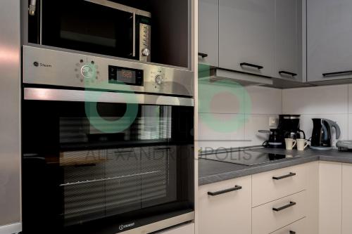 a kitchen with a stove and a microwave at Luxurious Tsimiski 3BDR 3rd Floor in Alexandroupoli